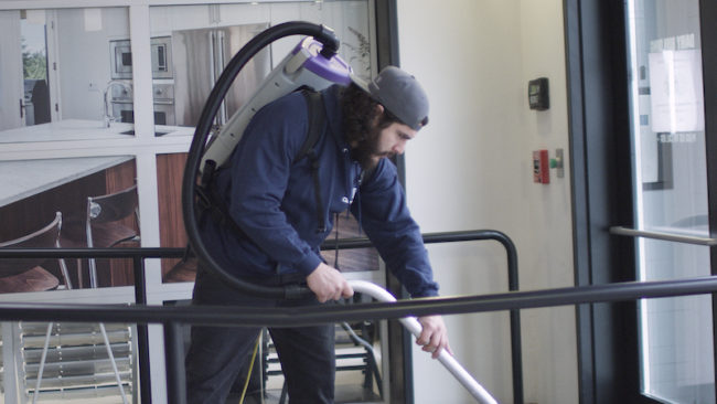 Cleansolution employee using a backpack vacuum.